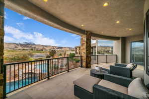 Balcony with view of pool area, an outdoor living space, and a mountain view