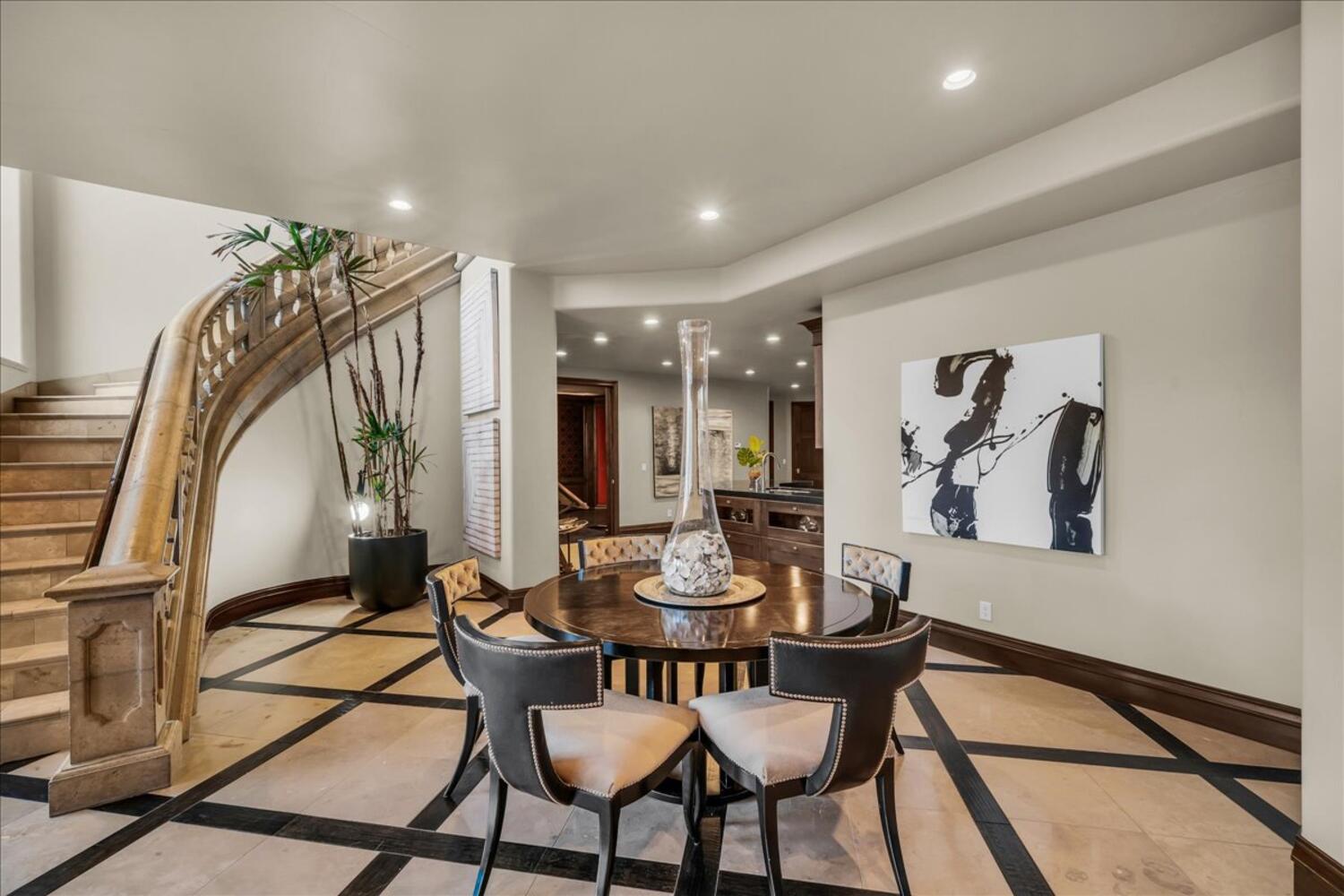 Dining room with inlaid floor details, recessed lighting, and stairs