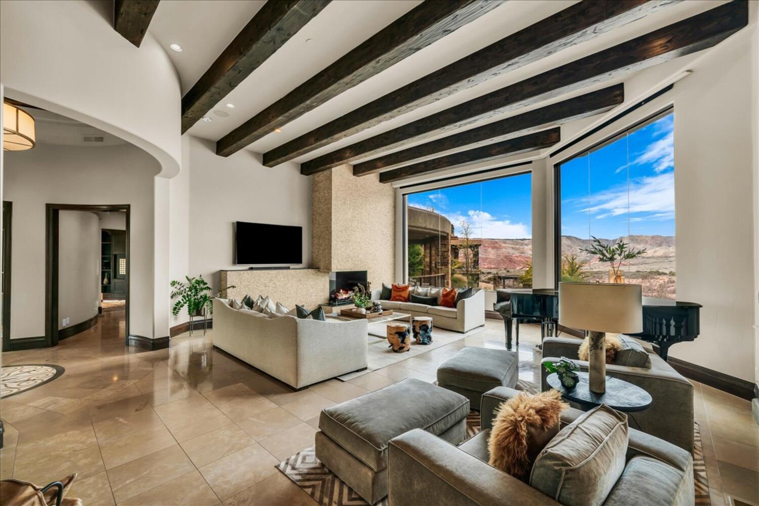 Living area featuring arched walkways, beam ceiling, and recessed lighting