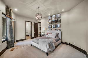 Carpeted bedroom with a chandelier, connected bathroom, and recessed lighting