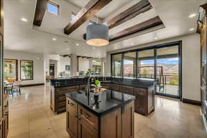 Kitchen featuring open floor plan, decorative light fixtures, dark brown cabinetry, plenty of natural light, and recessed lighting