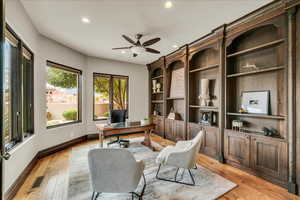 Office space featuring light wood-style floors, recessed lighting, ceiling fan, and built in shelves