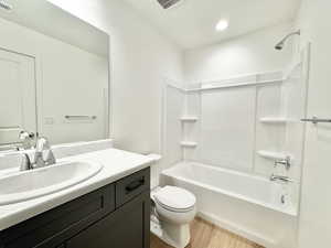 Full bathroom with shower / bath combination, vanity, and light wood finished floors