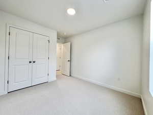 Unfurnished bedroom with carpet and a closet