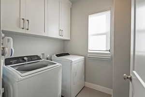 Laundry area with cabinet space and washing machine and clothes dryer