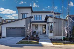 View of front facade featuring a porch and concrete driveway