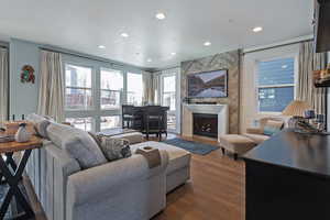 Living room with dark wood-style floors, a fireplace, and recessed lighting