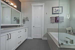 Full bathroom with double vanity, a bath, and a shower with door