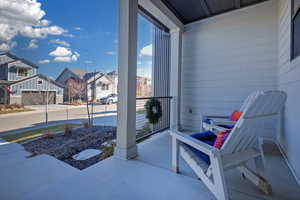 Covered porch featuring a residential view