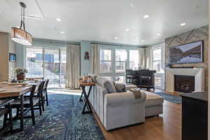 Living room with recessed lighting, dark wood finished floors, and a large fireplace