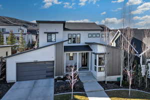 View of front of home with covered porch and concrete driveway