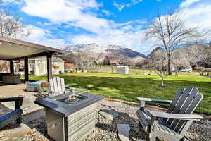 View of patio with a storage shed, a mountain view, and an outdoor fire pit