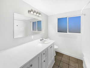 Full bathroom with vanity, dark tile patterned floors, and bathtub / shower combination