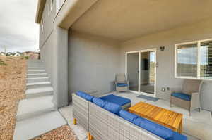 View of patio with an outdoor living space and stairs