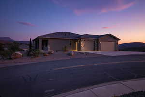 Ranch-style house with stone siding, a garage, concrete driveway, and stucco siding