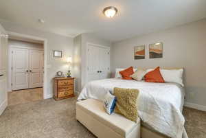 Carpeted bedroom featuring a closet and baseboards