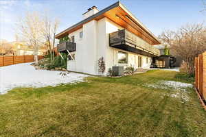 Back of house with a patio, a chimney, a balcony, brick siding, and entry steps