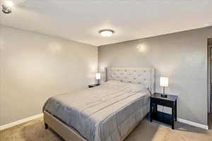 Bedroom featuring a textured ceiling and carpet floors