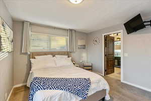 Bedroom featuring light carpet and connected bathroom