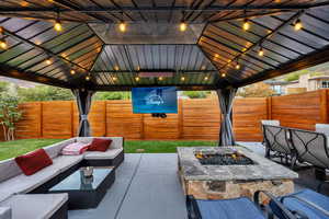 Fenced backyard with an outdoor living space with a fire pit and a patio