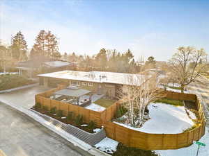 Snow covered property with a fenced backyard