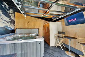 Below grade area with a jacuzzi, wood walls, and a garage