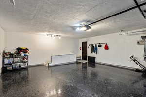 Garage with baseboards and a garage door opener