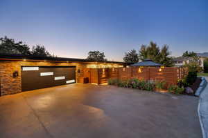 View of front of home featuring a gate, driveway, and stone siding