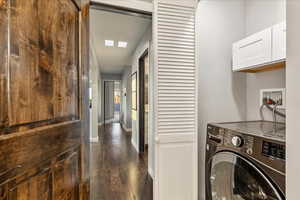 Laundry room featuring washer / dryer and dark wood-style flooring