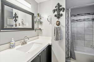 Bathroom with vanity and shower / bath combination with curtain