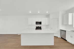 Kitchen featuring white cabinetry, recessed lighting, tasteful backsplash, a center island, and stainless steel appliances