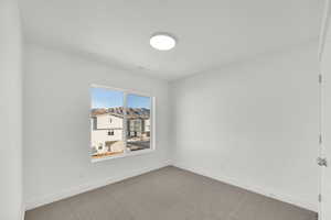 Spare room featuring baseboards and carpet flooring