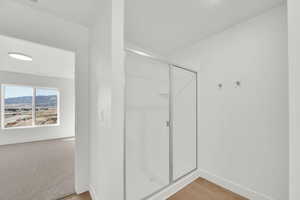 Full bath featuring a shower stall and light wood-type flooring