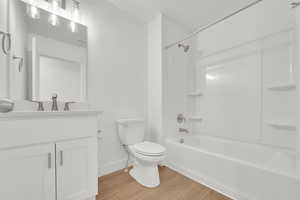 Full bath featuring vanity, shower / washtub combination, and light wood-style floors