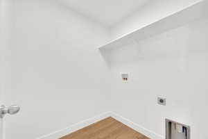 Washroom featuring hookup for a washing machine, light wood-style flooring, and hookup for an electric dryer