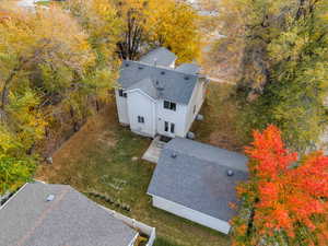 View of subject property featuring a tree filled landscape