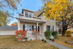View of front of home featuring a porch, a front yard, and brick siding