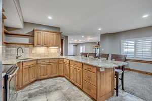 Kitchen with a kitchen breakfast bar, light stone countertops, electric range, tasteful backsplash, and open shelves
