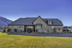 Rear view of property featuring stairway, a yard, a deck with mountain view, and stucco siding