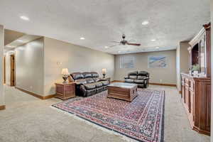 Living area featuring a textured ceiling, recessed lighting, light carpet, and ceiling fan