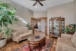 Living room featuring wood finished floors, ceiling fan, and french doors
