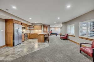 Kitchen featuring open floor plan, light carpet, stainless steel appliances, recessed lighting, and open shelves