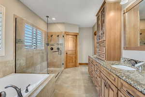 Full bath with vanity, a stall shower, and tiled tub