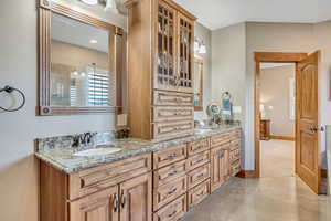 Full bath featuring double vanity and baseboards