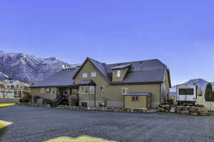 Back of house with a mountain view, a storage unit, stairway, and stucco siding