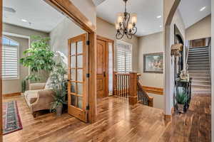 Foyer entrance with stairway, wood finished floors, recessed lighting, and a chandelier