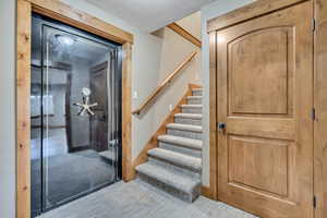 Foyer entrance with stairway, a textured ceiling, and carpet flooring