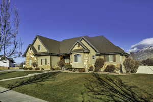 View of front facade featuring stone siding, stucco siding, and covered porch