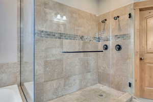 Full bath featuring tiled shower and a bath