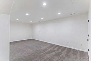 Empty room featuring recessed lighting and light carpet